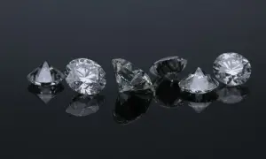 Błyszczące diamenty na czarnym tle. Wykres ceny diamentów mógłby pokazać ich wartość.