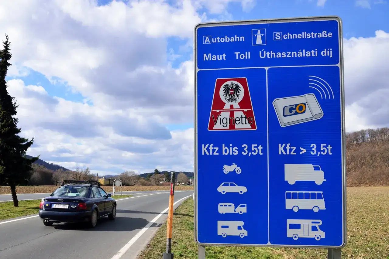 Znak drogowy informuje o opłatach za autostrady i drogi szybkiego ruchu w Austrii. Sprawdź czworak austriacki cena, by dowiedzieć się więcej o winietach.
