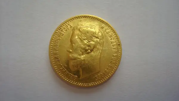 Złota moneta z profilem cara, ozdobiona rosyjskimi inskrypcjami. To historyczny 5 rubli złote.
